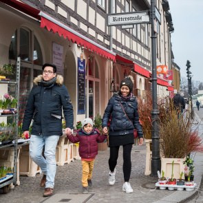 Ein Paar mit Migrationshintergrund läuft mit seiner Tochter durch die Altstadt von Berlin Spandau an einem Blumengeschäft vorbei.