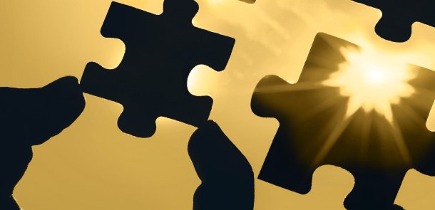 Puzzleteil zwischen zwei Fingern