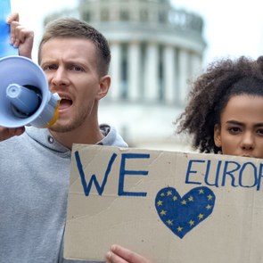 Young protesters with megaphones and Love Europe signs.
