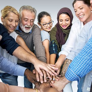 Menschen aus unterschiedlichen Kulturen legen ihre Hände übereinander
