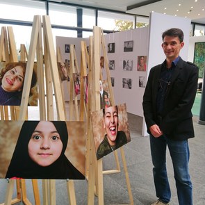 Der Fotograf Thomas Byczkowskia steht vor der Fotoausstellung Menschen keine Zahlen im Foyer der Bertelsmann Stiftung