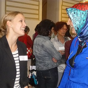 Zwei Frauen unterschiedlicher Nationalitäten unterhalten sich und lachen