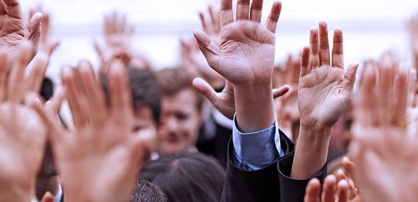 Menschen, die ihre Hand heben