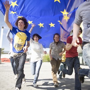 Eine Gruppe junger Menschen rennen mit einer EU-Flagge durch München.