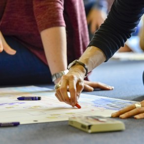 zwei Menschen arbeiten an einem Wandplakat