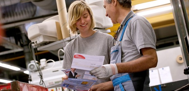 Mitarbeiter unterhalten sich über einen Flyer