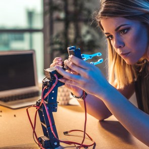 junge Frau vor Roboter