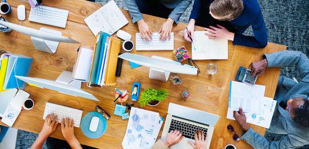 Schreibtisch von oben mit vielen Bildschirmen